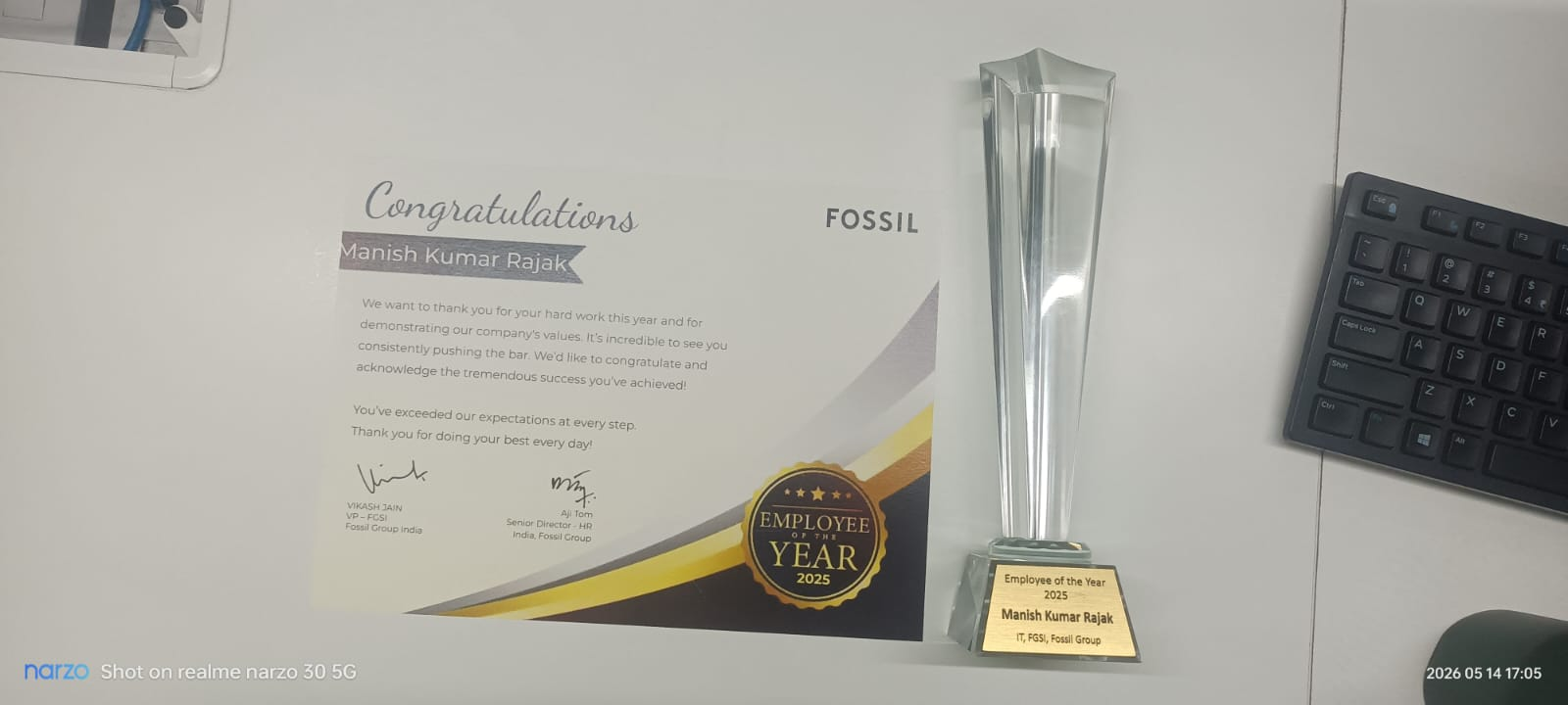 Employee of the Year 2025 certificate and crystal trophy awarded to Manish Kumar Rajak by Fossil Group